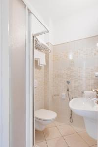 a bathroom with a toilet and a sink at Hotel De La Ville in Cesenatico