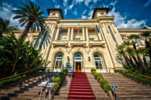 a building with a staircase leading up to a building with palm trees at Sanremo Luxury Apartament in Sanremo