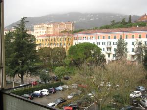ラ・スペツィアにあるurania houseの建物と車が並ぶ駐車場の景色