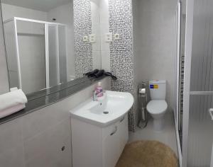 a white bathroom with a sink and a toilet at Luxury Apartment Eurotel in Struga