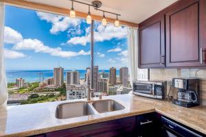 a kitchen with a large window with a view of the city at Hawaiian Monarch Penthouse 402 in Honolulu