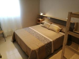 Un dormitorio con una cama grande y una escalera en Apartaments Els Temporers, en Corbera