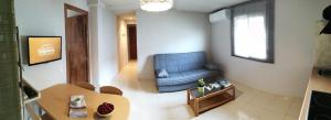 sala de estar con silla azul y mesa en Apartaments Els Temporers, en Corbera