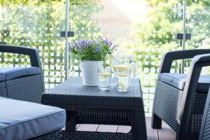 a table with glasses and a potted plant on a patio at LATO apartament Solna 11c z garażem in Kołobrzeg