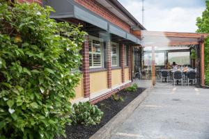 an outside view of a building with a table and chairs at Hotel-Resto-Bar Le Journel in Saint-Joseph-de-Beauce