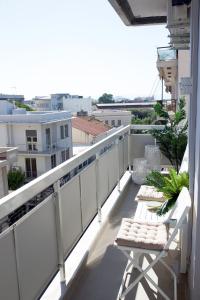 TRIA Urban Chania في مدينة خانيا: شرفة عليها سور أبيض وكراسي