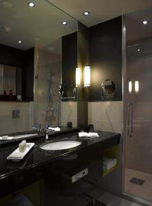 La salle de bains est pourvue d'un lavabo et d'une douche. dans l'établissement Hotel Fabian, à Helsinki