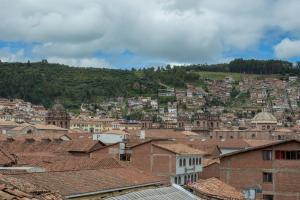 a view of a city with buildings and a mountain at Hospedaje Qori Punku in Cusco