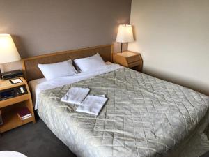 a hotel room with a bed with two towels on it at Hotel Grand Terrace Chitose in Chitose