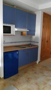 a kitchen with blue cabinets and a microwave at Maribel Ski in Sierra Nevada