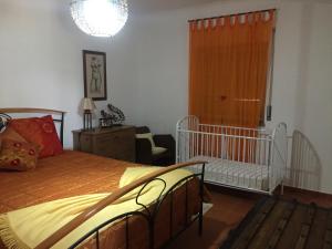 a bedroom with a bed and a crib in it at Holiday home Monte das Azinheiras in Arraiolos +42 photos