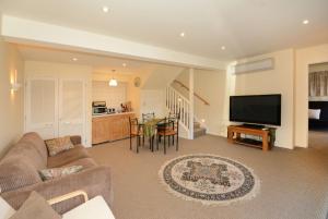 ein Wohnzimmer mit einem Sofa und einem Flachbild-TV in der Unterkunft Sleep on the Steepest Street in the World! in Dunedin