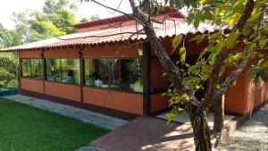 a house with people sitting in the window at Pousada Spa Prana Lorien in Santo Antônio do Leite