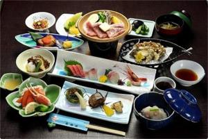 una mesa con muchos platos de comida. en Otowaya Ryokan en Yuzawa