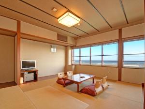 a living room with a table and a television at Iioka Shiosai Hotel in Asahi