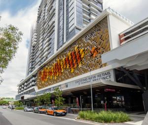 un edificio con coches estacionados frente a él en The Milton Brisbane en Brisbane