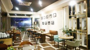 a restaurant with tables and chairs in a room at Golden Tulip Essential Belitung in Tanjungpandan