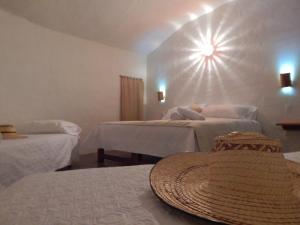 a room with two beds and a hat on a table at Entre Sombreros in Villa de Leyva