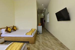 a bedroom with two beds and a flat screen tv at Hung Vuong Hotel in Buon Ma Thuot +24 photos