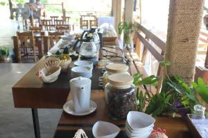 una mesa larga con tazas y platos. en Koh Yao Yai Hillside Resort en Ko Yao Yai