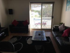 uma sala de estar com um sofá e uma mesa de centro em Adelaide - Semaphore Beach Front em Adelaide