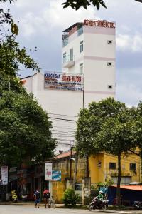 Hung Vuong Hotel في بون ما توت: مبنى أبيض طويل مع علامات على جانبه