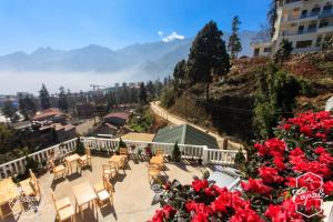 a balcony with tables and chairs and red roses at Sapa Capsule Hotel in Sa Pa