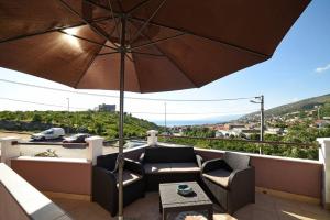 a patio with a couch and an umbrella at BMB Apartments in Senj