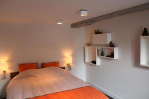 a bedroom with a bed with orange pillows and lights at Drabstraat 2 Apartment in Ghent