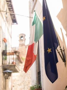 two flags are hanging on a building at Porta Del Tempo in Stroncone