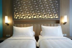 A bed or beds in a room at ibis Styles Cikarang