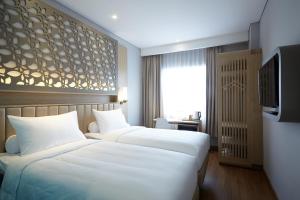 A bed or beds in a room at ibis Styles Cikarang