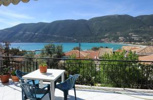 a table and chairs on a balcony with a view of the water at Mediterraneo studios in Vasiliki