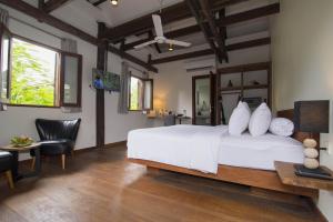 a bedroom with a white bed and a table and chairs at Enkosa 4-Bedroom Wooden Luxury House in Siem Reap +27 photos