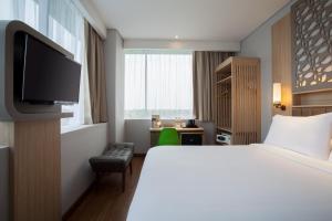 A bed or beds in a room at ibis Styles Cikarang