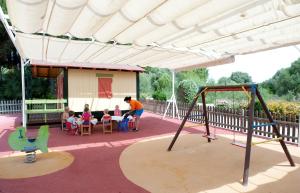 a group of children sitting at a table on a playground at Grupotel Playa Club in Son Xoriguer