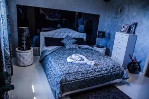 a bedroom with a bed with a blue bedspread at B&B Etna Ranch in Piedimonte Etneo