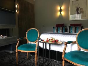 a hotel room with two chairs and a bed at Spa Suites at RAVEN in Hepburn Springs
