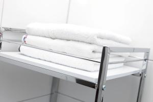 a stack of towels on a shelf in a bathroom at Pension Arkade Heilbronn in Heilbronn