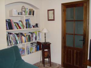 una habitación con estanterías llenas de libros y una lámpara en Mesa del Conde en San Felices de los Gallegos