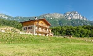 a house on a hill with mountains in the background at Maso Scricciolo Farm House in Vezzano