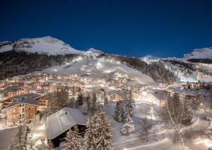 una ciudad en una montaña cubierta de nieve por la noche en Hotel Kristberg en Lech am Arlberg