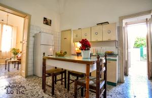 a kitchen with a table with chairs and a refrigerator at Le Volte di Lo Re in Surbo