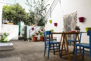 patio con tavolo in legno e sedie blu di Le Volte di Lo Re a Surbo