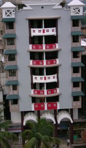 a building with red and white signs on it at Hotel Millennium in Guwahati