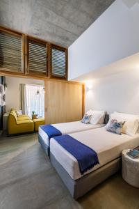 a bedroom with two beds and a yellow couch at Idolio Suite in Hersonissos