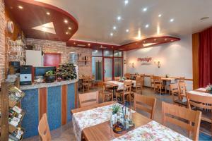 a dining room with tables and chairs in a restaurant at Family Hotel Prestige in Burgas