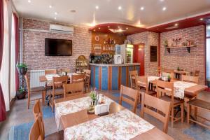 a restaurant with tables and chairs and a brick wall at Family Hotel Prestige in Burgas +65 photos