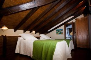 a bedroom with two beds with green and white sheets at Hotel Villa Miramar in Po
