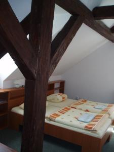 a bed in a room with wooden beams at Restaurace a Penzion Česká Hospoda in Heřmanice